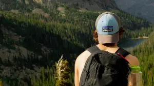 Homem sentado na pedra olhando para a montanha