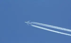 avião deixando rastro de chemtrails no céu