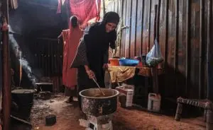 Refugiada somali Asha Abdikadir Ahmed, 42, cozinha usando briquetes energeticamente eficientes em seu restaurante em Bur Amino, Etiópia.