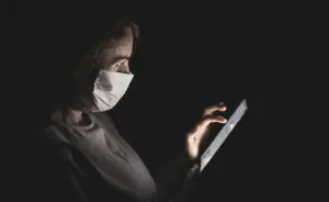 Mulher com máscara usando celular