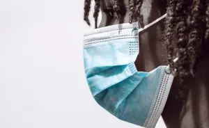 Pessoa negra usando máscara de lado