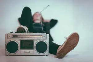 Pessoa deitada apoiando pé em um rádio