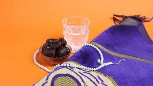 Uma tigela de passas ao lado de um copo de água