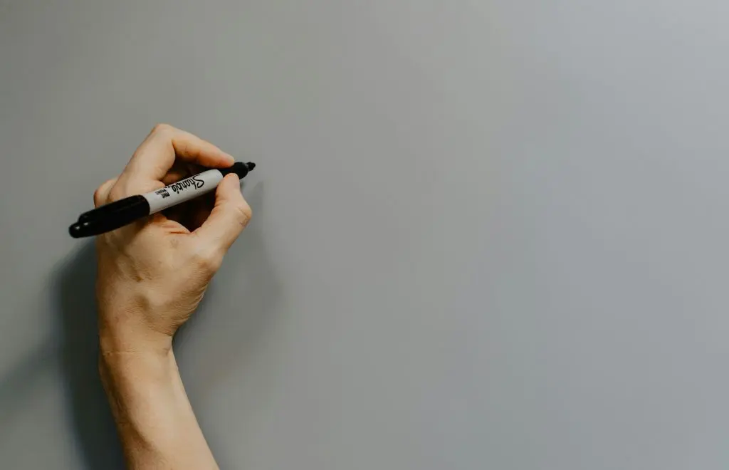 um indivíduo canhoto segurando uma caneta com a mão esquerda