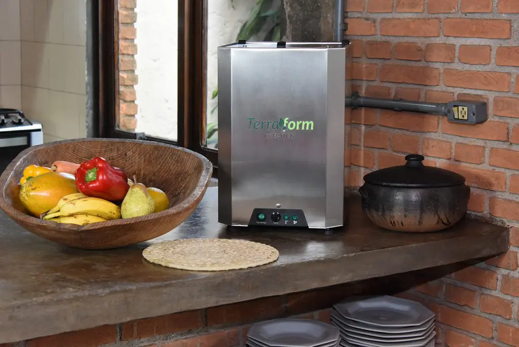 Reciclador doméstico de resíduos orgânicos da marca Terraform Kitchen, em ambiente de cozinha, mostrando a tecnologia aplicada à gestão do lixo.